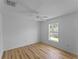 A bright bedroom features light hardwood floors and a window view at 6199 Stamp St, Port Charlotte, FL 33981