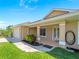 Tan home with double door entrance, a two-car garage, and a manicured front lawn with landscaping at 6199 Stamp St, Port Charlotte, FL 33981