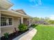 Pavered walkway leading to covered entryway; beautiful landscaping and manicured lawn at 6199 Stamp St, Port Charlotte, FL 33981