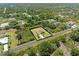 Aerial view of a one story home bordered by lush vegetation and a quiet road, surrounded by a natural landscape at 6199 Stamp St, Port Charlotte, FL 33981