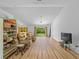 Spacious living room with wood floors, natural light, ceiling fan, and a sliding glass door to the yard at 6199 Stamp St, Port Charlotte, FL 33981