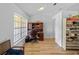 Home office with wood floors, bright natural light, and a built-in desk and shelving unit at 6199 Stamp St, Port Charlotte, FL 33981