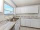 Kitchen features white cabinets, a stainless steel sink and marble-look countertops at 6231 Jordan St, North Port, FL 34287