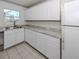 Well-lit kitchen offering white cabinets, marble-look countertops, and an updated stainless steel sink at 6231 Jordan St, North Port, FL 34287