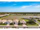 A high-angle view showcasing the house and the surrounding homes, lake, and greenery in the neighborhood at 629 Ibiza Loop, Venice, FL 34292