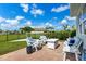 Landscaped backyard featuring a patio with outdoor seating, lush grass, and privacy fence at 629 Ibiza Loop, Venice, FL 34292