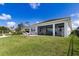 Spacious backyard with a covered patio, lush lawn, and a serene view of neighboring homes at 629 Ibiza Loop, Venice, FL 34292