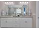 Bright bathroom vanity with dual sinks, granite countertops, and decorative mirror at 629 Ibiza Loop, Venice, FL 34292
