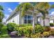 Close-up showcasing manicured landscaping, palm trees, and the home's architectural details at 629 Ibiza Loop, Venice, FL 34292