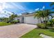 Beautiful house with a brick driveway, vibrant landscaping, and a two-car garage at 629 Ibiza Loop, Venice, FL 34292