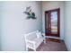 Inviting front porch with a decorative bench and a warm welcome mat near the red-accented front door at 629 Ibiza Loop, Venice, FL 34292