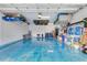 Spacious garage with overhead storage, blue epoxy floor, and ample space for vehicles and projects at 629 Ibiza Loop, Venice, FL 34292