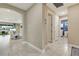 Hallway view showing entry to the living room and laundry room featuring blue brick-patterned accent wall at 629 Ibiza Loop, Venice, FL 34292