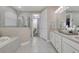 Elegant main bathroom featuring a glass shower, soaking tub, and double vanity at 629 Ibiza Loop, Venice, FL 34292