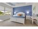 Well-lit main bedroom boasts an accent wall, stylish furnishings, and a large window at 629 Ibiza Loop, Venice, FL 34292