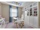 Bright office with a white desk, gold accents, and white shelving with glass doors at 629 Ibiza Loop, Venice, FL 34292
