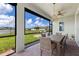 Covered patio with dining set, fan, and views of the lush backyard and neighborhood at 629 Ibiza Loop, Venice, FL 34292