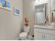 Clean powder room with neutral paint and a white vanity, sink, and toilet at 629 Ibiza Loop, Venice, FL 34292