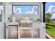 Outdoor kitchen with stainless steel grill, beverage center, and ample counter space at 629 Ibiza Loop, Venice, FL 34292