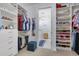 Organized walk-in closet with clothes, shoe rack and view to the laundry area at 629 Ibiza Loop, Venice, FL 34292