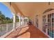 Spacious balcony with tiled floor, arched columns, white railings, and French doors overlooking tropical scenery at 63 Palm Dr, Placida, FL 33946
