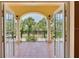 Balcony view showing decorative tile, archways, white pillars, and tropical greenery beyond at 63 Palm Dr, Placida, FL 33946