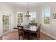 Dining room with natural light from three windows, a wooden dining table, and terracotta flooring at 63 Palm Dr, Placida, FL 33946