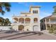 Beautiful three-story home with white pillars, balconies, and a brick driveway at 63 Palm Dr, Placida, FL 33946