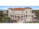 Elegant Mediterranean-style home boasting arched balconies, white railings, and lush landscaping for an inviting outdoor space at 63 Palm Dr, Placida, FL 33946