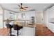 White kitchen with terracotta floors, granite countertops, stainless steel appliances and a large central island at 63 Palm Dr, Placida, FL 33946
