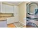 Modern laundry room with a stacked washer and dryer, ample cabinets, and a convenient countertop at 63 Palm Dr, Placida, FL 33946