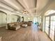 Spacious living room with beamed ceiling, tile floors, large sectional sofa, and an abundance of natural light at 63 Palm Dr, Placida, FL 33946