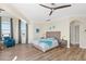 Bright, airy main bedroom with wood floors, coastal decor, fan, and large windows with curtains at 63 Palm Dr, Placida, FL 33946