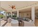 Relaxing covered patio with comfortable seating and plenty of space for entertaining with ceiling fans and travertine tile at 63 Palm Dr, Placida, FL 33946