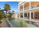 Luxury home featuring an elegant outdoor space with a large pool, balconies, and travertine tile at 63 Palm Dr, Placida, FL 33946