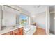 Bright bathroom featuring double sinks, garden tub with a large window, and a separate shower at 632 Tanana Fall Dr, Ruskin, FL 33570