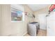 Functional laundry room featuring a modern washer and dryer, ample storage space, and natural light from a window at 632 Tanana Fall Dr, Ruskin, FL 33570
