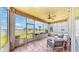 Relaxing screened porch with comfortable seating, ceiling fan, and serene views of the lake and landscaped backyard at 632 Tanana Fall Dr, Ruskin, FL 33570