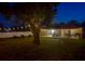 Backyard view at dusk with string lights highlighting a patio, dining area, and a fire pit at 6497 Honeycomb Cir, North Port, FL 34291