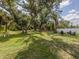 Large backyard featuring a fire pit with chairs and a white fence at 6497 Honeycomb Cir, North Port, FL 34291