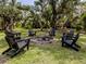 Backyard area features a stone fire pit and black Adirondack chairs at 6497 Honeycomb Cir, North Port, FL 34291