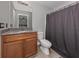 Bathroom featuring a wood vanity with granite top, a mirror and a shower with a grey shower curtain at 6497 Honeycomb Cir, North Port, FL 34291