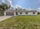 Charming single-story home with a lush front lawn, a two-car garage, and a welcoming entrance at 6497 Honeycomb Cir, North Port, FL 34291