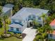 Aerial view showcasing a two-story home with a gray tile roof, complemented by lush landscaping and a spacious driveway at 678 Clear Creek Dr, Osprey, FL 34229