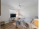 Cozy bedroom with wood-look flooring, ceiling fan, and natural light from the window at 678 Clear Creek Dr, Osprey, FL 34229