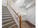 Inviting foyer with a staircase, wooden floors, and a stylish red rug leading to the bright front door at 678 Clear Creek Dr, Osprey, FL 34229