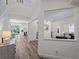 Hallway features wood flooring, a view of the kitchen, living room, and natural light, connecting key living spaces at 678 Clear Creek Dr, Osprey, FL 34229