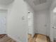 Bright hallway featuring wood-look flooring, neutral walls, and access to a laundry room at 678 Clear Creek Dr, Osprey, FL 34229