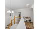 Bright upstairs hallway featuring a decorative chandelier and a sitting bench at 678 Clear Creek Dr, Osprey, FL 34229