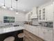 Bright kitchen featuring stone countertops, white cabinetry, and stainless steel appliances at 678 Clear Creek Dr, Osprey, FL 34229